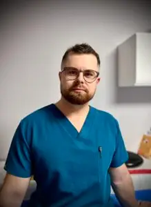 Fizjoterapeuta Krzysztof Dowolski w gabinecie.